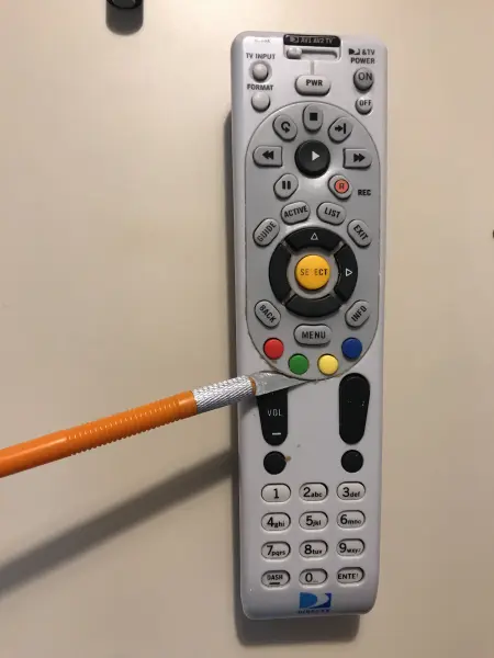 Photo of a man who is not that wise using an X-Acto brand knife to pry the top of a TV remote off. ** CAUTION **