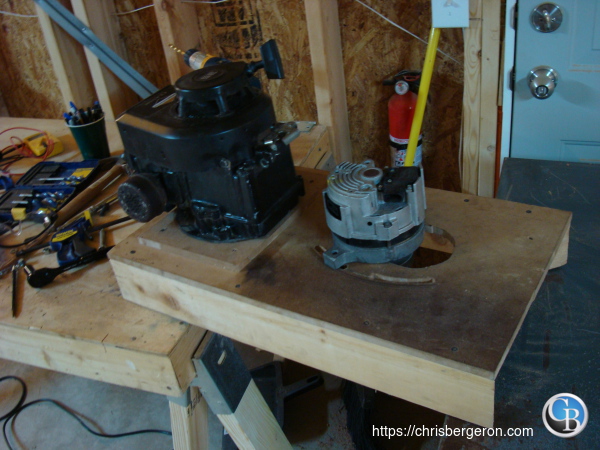 Photo of a crudely made electricity generator made from a lawnmower engine and a car alternator. Gotta power my gadgets